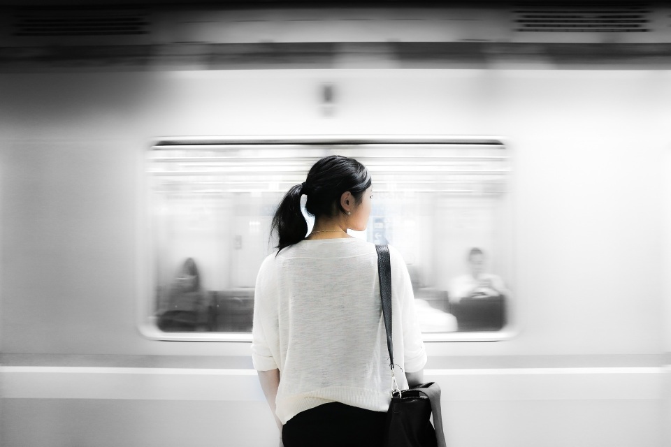 Image of woman on platform watching speeding train going past